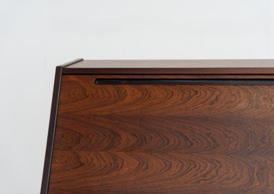“No. 63” secretary by Kai Kristiansen for Torring Møbelfabrik (Denmark, 1960s). This very hard to find piece is one of our favorite secretaries and an example of high quality Danish craftsmanship. It features stunning aesthetics and nifty details like the sculptural handles or the convenient pivoting drop-down leaf. This particular piece is crafted out of rosewood and has an extraordinary woodgrain! It is in splendid condition with a minor repair mark on the lowest drawer.