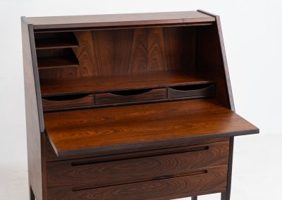“No. 63” secretary by Kai Kristiansen for Torring Møbelfabrik (Denmark, 1960s). This very hard to find piece is one of our favorite secretaries and an example of high quality Danish craftsmanship. It features stunning aesthetics and nifty details like the sculptural handles or the convenient pivoting drop-down leaf. This particular piece is crafted out of rosewood and has an extraordinary woodgrain! It is in splendid condition with a minor repair mark on the lowest drawer.