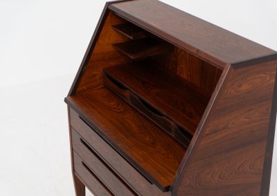 “No. 63” secretary by Kai Kristiansen for Torring Møbelfabrik (Denmark, 1960s). This very hard to find piece is one of our favorite secretaries and an example of high quality Danish craftsmanship. It features stunning aesthetics and nifty details like the sculptural handles or the convenient pivoting drop-down leaf. This particular piece is crafted out of rosewood and has an extraordinary woodgrain! It is in splendid condition with a minor repair mark on the lowest drawer.