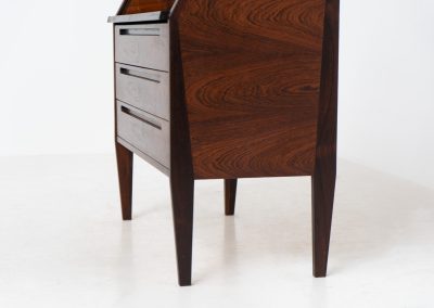 “No. 63” secretary by Kai Kristiansen for Torring Møbelfabrik (Denmark, 1960s). This very hard to find piece is one of our favorite secretaries and an example of high quality Danish craftsmanship. It features stunning aesthetics and nifty details like the sculptural handles or the convenient pivoting drop-down leaf. This particular piece is crafted out of rosewood and has an extraordinary woodgrain! It is in splendid condition with a minor repair mark on the lowest drawer.