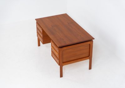 Teak writing desk by Arne Vodder for G.V. Møbler (Denmark, 1960s). This exceptionally beautiful piece is a true example of top-quality Danish craftsmanship. Made from teak, it showcases elegant aesthetics with softly rounded edges and a floating desk top. It contains six very deep drawers and a finished backside, making it an ideal piece for placement in the center of a room. The desk is in excellent condition.