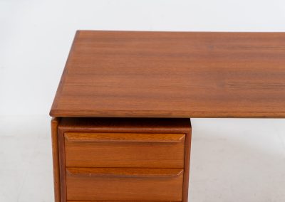 Teak writing desk by Arne Vodder for G.V. Møbler (Denmark, 1960s). This exceptionally beautiful piece is a true example of top-quality Danish craftsmanship. Made from teak, it showcases elegant aesthetics with softly rounded edges and a floating desk top. It contains six very deep drawers and a finished backside, making it an ideal piece for placement in the center of a room. The desk is in excellent condition.