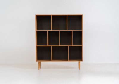 Oak bookcase by Kurt Østervig (Denmark, 1960s). A minimalistic bookcase crated in oak with vertical adjustable shelves and a contrasting dark back plate. In good condition with some discoloration on the inside.