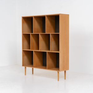 Oak bookcase by Kurt Østervig (Denmark, 1960s). A minimalistic bookcase crated in oak with vertical adjustable shelves and a contrasting dark back plate. In good condition with some discoloration on the inside.