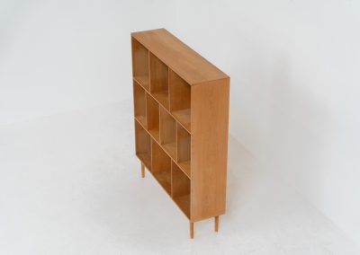 Oak bookcase by Kurt Østervig (Denmark, 1960s). A minimalistic bookcase crated in oak with vertical adjustable shelves and a contrasting dark back plate. In good condition with some discoloration on the inside.