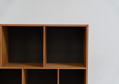 Oak bookcase by Kurt Østervig (Denmark, 1960s). A minimalistic bookcase crated in oak with vertical adjustable shelves and a contrasting dark back plate. In good condition with some discoloration on the inside.
