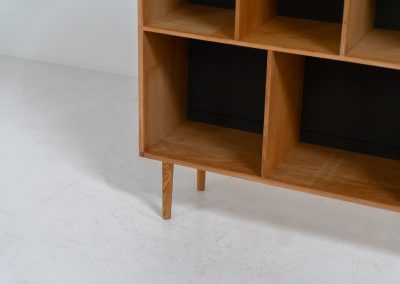 Oak bookcase by Kurt Østervig (Denmark, 1960s). A minimalistic bookcase crated in oak with vertical adjustable shelves and a contrasting dark back plate. In good condition with some discoloration on the inside.