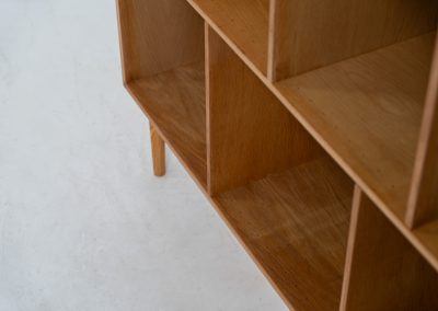 Oak bookcase by Kurt Østervig (Denmark, 1960s). A minimalistic bookcase crated in oak with vertical adjustable shelves and a contrasting dark back plate. In good condition with some discoloration on the inside.