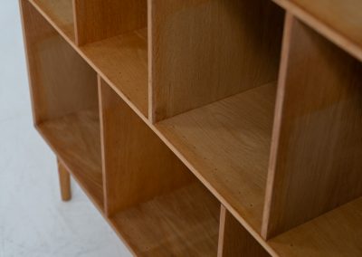 Oak bookcase by Kurt Østervig (Denmark, 1960s). A minimalistic bookcase crated in oak with vertical adjustable shelves and a contrasting dark back plate. In good condition with some discoloration on the inside.