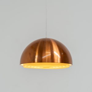 Copper “Louisiana” pendant light by Jørgen Bo & Vilhelm Wohlert for Louis Poulsen (Denmark, 1960s). A refined, sculptural design in warm copper, giving off a soft, glare-free light thanks to its layered inner shade. Originally created in connection with the Louisiana Museum of Modern Art, where both architects were closely involved for decades. Beautiful patina, timeless proportions. Effortless Danish design that works perfectly above a dining table or as a subtle focal point. In very good condition.