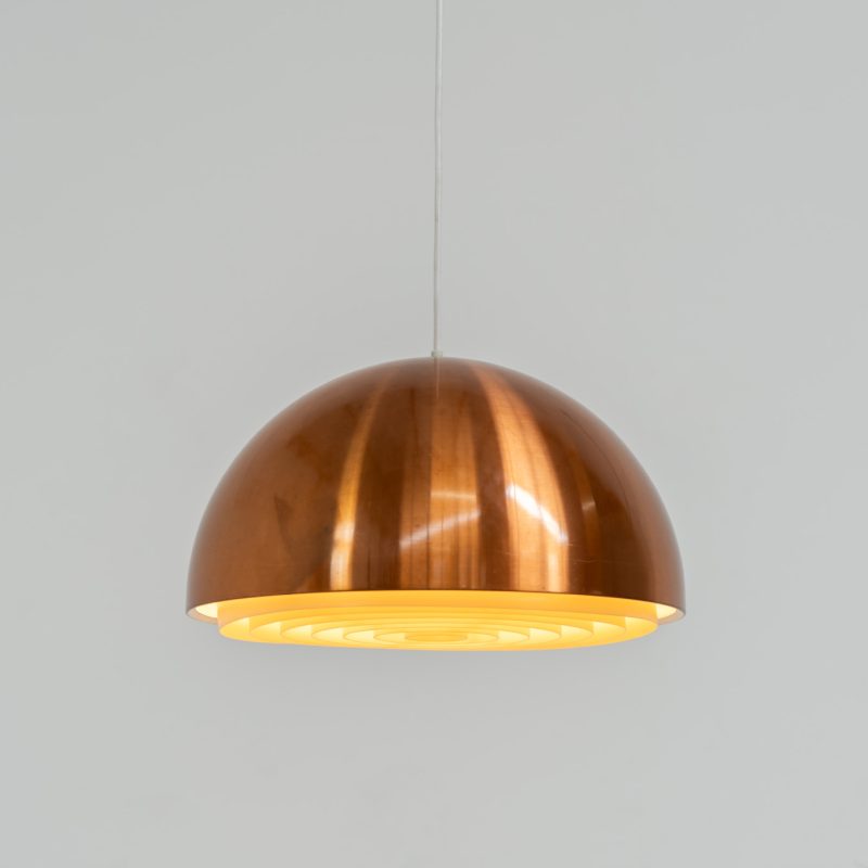 Copper “Louisiana” pendant light by Jørgen Bo & Vilhelm Wohlert for Louis Poulsen (Denmark, 1960s). A refined, sculptural design in warm copper, giving off a soft, glare-free light thanks to its layered inner shade. Originally created in connection with the Louisiana Museum of Modern Art, where both architects were closely involved for decades. Beautiful patina, timeless proportions. Effortless Danish design that works perfectly above a dining table or as a subtle focal point. In very good condition.