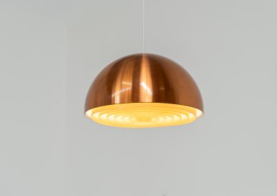 Copper “Louisiana” pendant light by Jørgen Bo & Vilhelm Wohlert for Louis Poulsen (Denmark, 1960s). A refined, sculptural design in warm copper, giving off a soft, glare-free light thanks to its layered inner shade. Originally created in connection with the Louisiana Museum of Modern Art, where both architects were closely involved for decades. Beautiful patina, timeless proportions. Effortless Danish design that works perfectly above a dining table or as a subtle focal point. In very good condition.