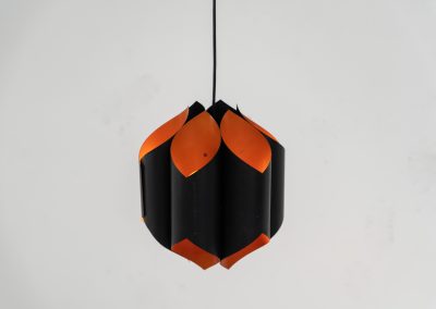 Sculptural pendant light by Bent Karlby for Lyfa (Denmark, 1960s). A bold, architectural design with folded metal shades in black and orange, creating a striking contrast and a warm, indirect glow. The layered construction plays with light and shadow, giving the piece a dynamic, almost graphic presence. A true mid-century statement. Compact, sculptural, and highly distinctive. Perfect as a focal point in any interior. In very good condition with age related wear.
