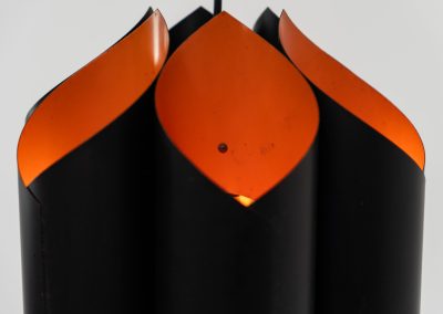 Sculptural pendant light by Bent Karlby for Lyfa (Denmark, 1960s). A bold, architectural design with folded metal shades in black and orange, creating a striking contrast and a warm, indirect glow. The layered construction plays with light and shadow, giving the piece a dynamic, almost graphic presence. A true mid-century statement. Compact, sculptural, and highly distinctive. Perfect as a focal point in any interior. In very good condition with age related wear.