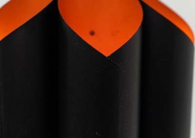 Sculptural pendant light by Bent Karlby for Lyfa (Denmark, 1960s). A bold, architectural design with folded metal shades in black and orange, creating a striking contrast and a warm, indirect glow. The layered construction plays with light and shadow, giving the piece a dynamic, almost graphic presence. A true mid-century statement. Compact, sculptural, and highly distinctive. Perfect as a focal point in any interior. In very good condition with age related wear.