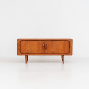 Beautiful lowboard with tambour doors by Svend Dyrlund (Denmark, 1960s). This elegant Danish piece, crafted in teak, features nice organic edges, refined tambour doors, and beautiful solid handles. The back has a factory hole that can be screwed open for cable management, making it a perfect piece for a television or audio gear! This piece is in splendid condition!