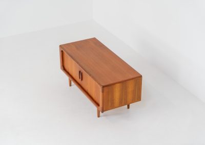Beautiful lowboard with tambour doors by Svend Dyrlund (Denmark, 1960s). This elegant Danish piece, crafted in teak, features nice organic edges, refined tambour doors, and beautiful solid handles. The back has a factory hole that can be screwed open for cable management, making it a perfect piece for a television or audio gear! This piece is in splendid condition!