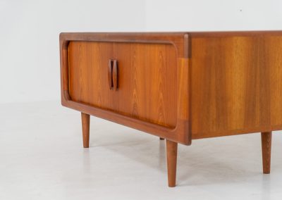 Beautiful lowboard with tambour doors by Svend Dyrlund (Denmark, 1960s). This elegant Danish piece, crafted in teak, features nice organic edges, refined tambour doors, and beautiful solid handles. The back has a factory hole that can be screwed open for cable management, making it a perfect piece for a television or audio gear! This piece is in splendid condition!
