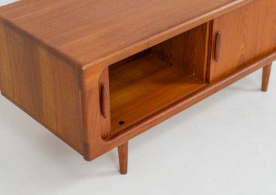 Beautiful lowboard with tambour doors by Svend Dyrlund (Denmark, 1960s). This elegant Danish piece, crafted in teak, features nice organic edges, refined tambour doors, and beautiful solid handles. The back has a factory hole that can be screwed open for cable management, making it a perfect piece for a television or audio gear! This piece is in splendid condition!