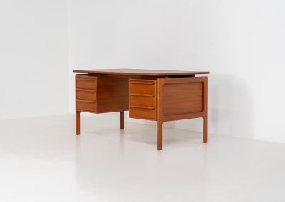 Teak writing desk by Arne Vodder for G.V. Møbler (Denmark, 1960s). This exceptionally beautiful piece is a true example of top-quality Danish craftsmanship. Made from teak, it showcases elegant aesthetics with softly rounded edges and a floating desk top. It contains six very deep drawers and a finished backside, making it an ideal piece for placement in the center of a room. The desk is in excellent condition.