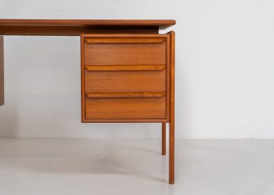 Teak writing desk by Arne Vodder for G.V. Møbler (Denmark, 1960s). This exceptionally beautiful piece is a true example of top-quality Danish craftsmanship. Made from teak, it showcases elegant aesthetics with softly rounded edges and a floating desk top. It contains six very deep drawers and a finished backside, making it an ideal piece for placement in the center of a room. The desk is in excellent condition.
