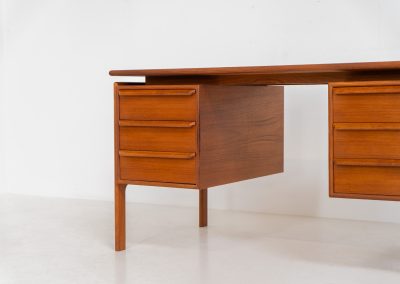 Teak writing desk by Arne Vodder for G.V. Møbler (Denmark, 1960s). This exceptionally beautiful piece is a true example of top-quality Danish craftsmanship. Made from teak, it showcases elegant aesthetics with softly rounded edges and a floating desk top. It contains six very deep drawers and a finished backside, making it an ideal piece for placement in the center of a room. The desk is in excellent condition.