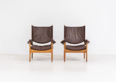 Pair of “Modus” armchairs by Kristian Vedel for Søren Willadsen (Denmark, 1960s). A rare and authentic set of two lounge chairs crafted from solid oak with beautifully detailed joinery. The frames have been carefully refreshed while preserving the wood's original character and warm patina. The brown leather has been cleaned and conditioned, showing attractive age and wear consistent with its vintage nature. A great example of Danish mid-century design, combining elegant sculptural lines with exceptional comfort thanks to the wide seats, suspended leather backs, and generous cushions.