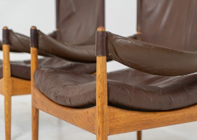 Pair of “Modus” armchairs by Kristian Vedel for Søren Willadsen (Denmark, 1960s). A rare and authentic set of two lounge chairs crafted from solid oak with beautifully detailed joinery. The frames have been carefully refreshed while preserving the wood's original character and warm patina. The brown leather has been cleaned and conditioned, showing attractive age and wear consistent with its vintage nature. A great example of Danish mid-century design, combining elegant sculptural lines with exceptional comfort thanks to the wide seats, suspended leather backs, and generous cushions.
