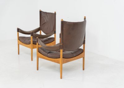 Pair of “Modus” armchairs by Kristian Vedel for Søren Willadsen (Denmark, 1960s). A rare and authentic set of two lounge chairs crafted from solid oak with beautifully detailed joinery. The frames have been carefully refreshed while preserving the wood's original character and warm patina. The brown leather has been cleaned and conditioned, showing attractive age and wear consistent with its vintage nature. A great example of Danish mid-century design, combining elegant sculptural lines with exceptional comfort thanks to the wide seats, suspended leather backs, and generous cushions.