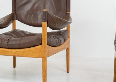 Pair of “Modus” armchairs by Kristian Vedel for Søren Willadsen (Denmark, 1960s). A rare and authentic set of two lounge chairs crafted from solid oak with beautifully detailed joinery. The frames have been carefully refreshed while preserving the wood's original character and warm patina. The brown leather has been cleaned and conditioned, showing attractive age and wear consistent with its vintage nature. A great example of Danish mid-century design, combining elegant sculptural lines with exceptional comfort thanks to the wide seats, suspended leather backs, and generous cushions.