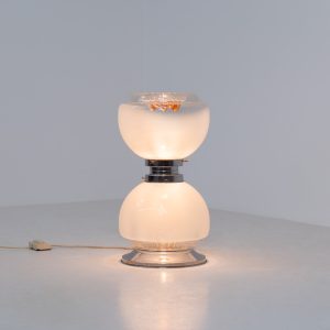 Floor lamp by Toni Zuccheri for Mazzega (Italy, 1970s). 1970s floor lamp by Toni Zuccheri for Mazzega, combining sculptural opaline Murano glass with refined chrome details. The design is highlighted by subtle amber, drip-like inclusions, an iconic Zuccheri signature. When lit, it casts a warm, atmospheric glow that enhances the soft translucency of the glass, making it both a functional light source and a collectible piece of Italian design. The lamp can be used as a floor lamp, or a large table lamp. Splendid condition.