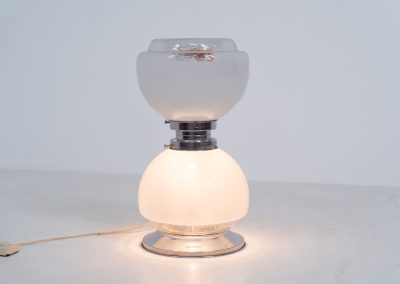 Floor lamp by Toni Zuccheri for Mazzega (Italy, 1970s). 1970s floor lamp by Toni Zuccheri for Mazzega, combining sculptural opaline Murano glass with refined chrome details. The design is highlighted by subtle amber, drip-like inclusions, an iconic Zuccheri signature. When lit, it casts a warm, atmospheric glow that enhances the soft translucency of the glass, making it both a functional light source and a collectible piece of Italian design. The lamp can be used as a floor lamp, or a large table lamp. Splendid condition.