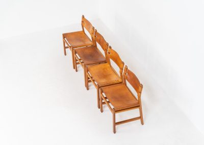 Oak & leather dining chairs (Denmark, 1960s). This exceptional set of dining chairs features solid oak frames paired with saddle leather seats. The design is reminiscent of Børge Mogensen’s “Spanish” dining chairs and could possibly be an lesser-known design by Mogensen, although this cannot be confirmed. The leather is in well-used condition with a beautiful, authentic patina. It shows some surface cracking, but this is limited to the top layer only and does not affect the structural integrity or strength of the seats.