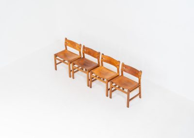 Oak & leather dining chairs (Denmark, 1960s). This exceptional set of dining chairs features solid oak frames paired with saddle leather seats. The design is reminiscent of Børge Mogensen’s “Spanish” dining chairs and could possibly be an lesser-known design by Mogensen, although this cannot be confirmed. The leather is in well-used condition with a beautiful, authentic patina. It shows some surface cracking, but this is limited to the top layer only and does not affect the structural integrity or strength of the seats.