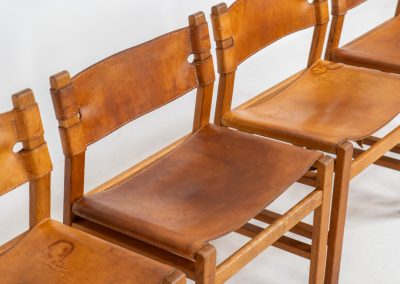 Oak & leather dining chairs (Denmark, 1960s). This exceptional set of dining chairs features solid oak frames paired with saddle leather seats. The design is reminiscent of Børge Mogensen’s “Spanish” dining chairs and could possibly be an lesser-known design by Mogensen, although this cannot be confirmed. The leather is in well-used condition with a beautiful, authentic patina. It shows some surface cracking, but this is limited to the top layer only and does not affect the structural integrity or strength of the seats.