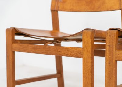 Oak & leather dining chairs (Denmark, 1960s). This exceptional set of dining chairs features solid oak frames paired with saddle leather seats. The design is reminiscent of Børge Mogensen’s “Spanish” dining chairs and could possibly be an lesser-known design by Mogensen, although this cannot be confirmed. The leather is in well-used condition with a beautiful, authentic patina. It shows some surface cracking, but this is limited to the top layer only and does not affect the structural integrity or strength of the seats.