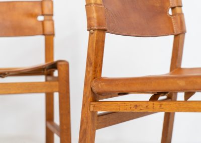 Oak & leather dining chairs (Denmark, 1960s). This exceptional set of dining chairs features solid oak frames paired with saddle leather seats. The design is reminiscent of Børge Mogensen’s “Spanish” dining chairs and could possibly be an lesser-known design by Mogensen, although this cannot be confirmed. The leather is in well-used condition with a beautiful, authentic patina. It shows some surface cracking, but this is limited to the top layer only and does not affect the structural integrity or strength of the seats.