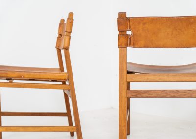Oak & leather dining chairs (Denmark, 1960s). This exceptional set of dining chairs features solid oak frames paired with saddle leather seats. The design is reminiscent of Børge Mogensen’s “Spanish” dining chairs and could possibly be an lesser-known design by Mogensen, although this cannot be confirmed. The leather is in well-used condition with a beautiful, authentic patina. It shows some surface cracking, but this is limited to the top layer only and does not affect the structural integrity or strength of the seats.
