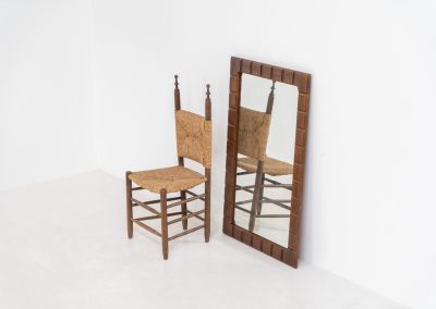 Sculptural graphic wall mirror (Sweden, 1960s). This wall mirror is made out of stained oak and offers a deeply carved geometric facade which creates a strong sense of rhythm and depth. The mirror is in very good condition.