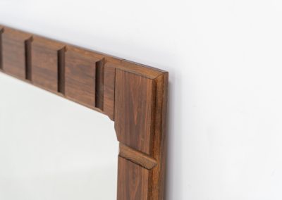 Sculptural graphic wall mirror (Sweden, 1960s). This wall mirror is made out of stained oak and offers a deeply carved geometric facade which creates a strong sense of rhythm and depth. The mirror is in very good condition.
