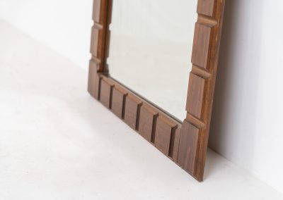 Sculptural graphic wall mirror (Sweden, 1960s). This wall mirror is made out of stained oak and offers a deeply carved geometric facade which creates a strong sense of rhythm and depth. The mirror is in very good condition.