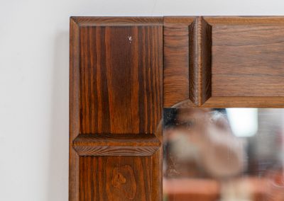Sculptural graphic wall mirror (Sweden, 1960s). This wall mirror is made out of stained oak and offers a deeply carved geometric facade which creates a strong sense of rhythm and depth. The mirror is in very good condition.