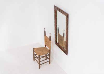 Sculptural graphic wall mirror (Sweden, 1960s). This wall mirror is made out of stained oak and offers a deeply carved geometric facade which creates a strong sense of rhythm and depth. The mirror is in very good condition.