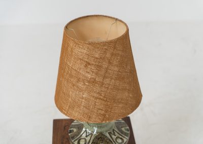 Ceramic table lamp by Søholm for Bornholmsk (Denmark, 1960s). This lamp offers a refined blend of beautiful textures and timeless design. It has handcrafted ceramic base with earthy colors, complimented by a raffia shade. The lamp is marked and remains in splendid condition.
