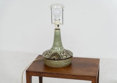 Ceramic table lamp by Søholm for Bornholmsk (Denmark, 1960s). This lamp offers a refined blend of beautiful textures and timeless design. It has handcrafted ceramic base with earthy colors, complimented by a raffia shade. The lamp is marked and remains in splendid condition.