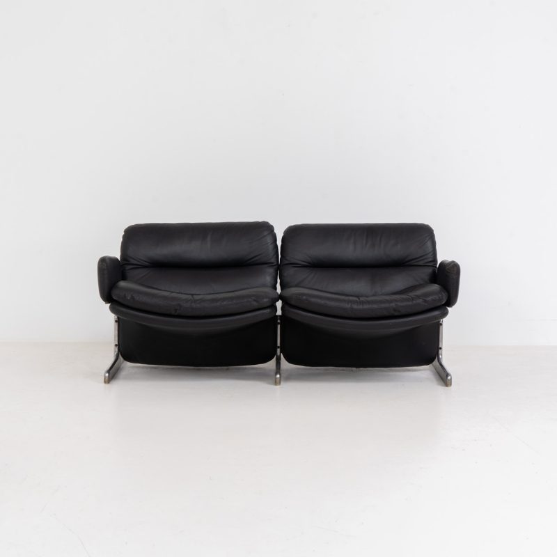 Exceptional “Doppiosandwich” sofa by Ammanati & Vitelli for Brunati (Italy, 1970s). Striking Italian design from the 1970s, designed by Titina Ammannati and Giampiero Vitelli for Brunati. The Doppiosandwich sofa is characterized by its sculptural form, comfortable “sandwich” leather cushions and distinctive chromed metal base. Upholstered in black leather, it offers exceptional comfort while maintaining a strong architectural presence. A sought-after design that effortlessly combines Italian elegance, comfort and timeless modernist appeal. The armrests can be easily removed for a more sleek and minimastic appearance. The sofa remains in very good condition and contains the original certificate.