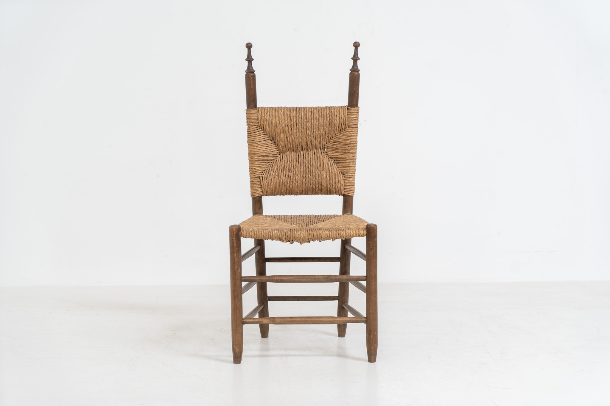 Vintage Spanish side chair, 1950s. This chair features a beautifully sculptural silhouette, crafted from a solid stained beech frame with a handwoven rush seat. Its minimalist yet expressive form adds warmth and texture to any interior. In good condition, with a rich natural patina and visible signs of use that enhance its character.