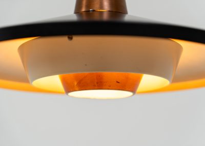 Striking Danish pendant light (Denmark, 1950s). This striking vintage pendant lamp features a refined combination of copper, lacquered metal and teak wood. Its perfectly balanced and sculptural silhouette creates a warm, atmospheric glow while adding a bold design statement to any interior. The lamp is in very good condition with a stunning patina to the copper.