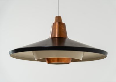 Striking Danish pendant light (Denmark, 1950s). This striking vintage pendant lamp features a refined combination of copper, lacquered metal and teak wood. Its perfectly balanced and sculptural silhouette creates a warm, atmospheric glow while adding a bold design statement to any interior. The lamp is in very good condition with a stunning patina to the copper.