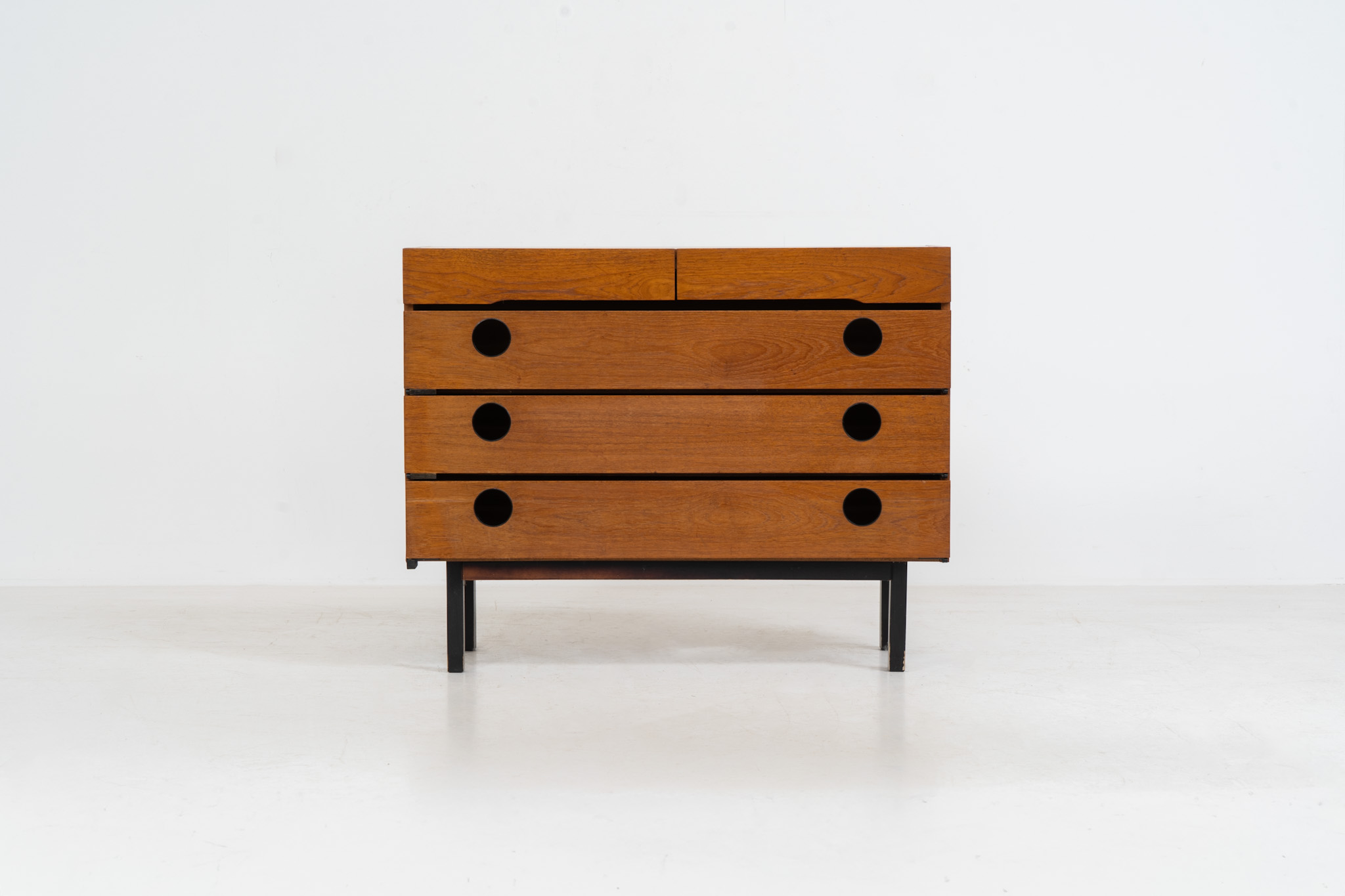 Teak shoe cabinet (Germany, 1960s). The cabinet features two small drawers and three shelves for shoe storage. It is made of teak and has a black lacquered frame with black inset handles that allow for proper ventilation. The cabinet is in good condition, with some visible signs of use.
